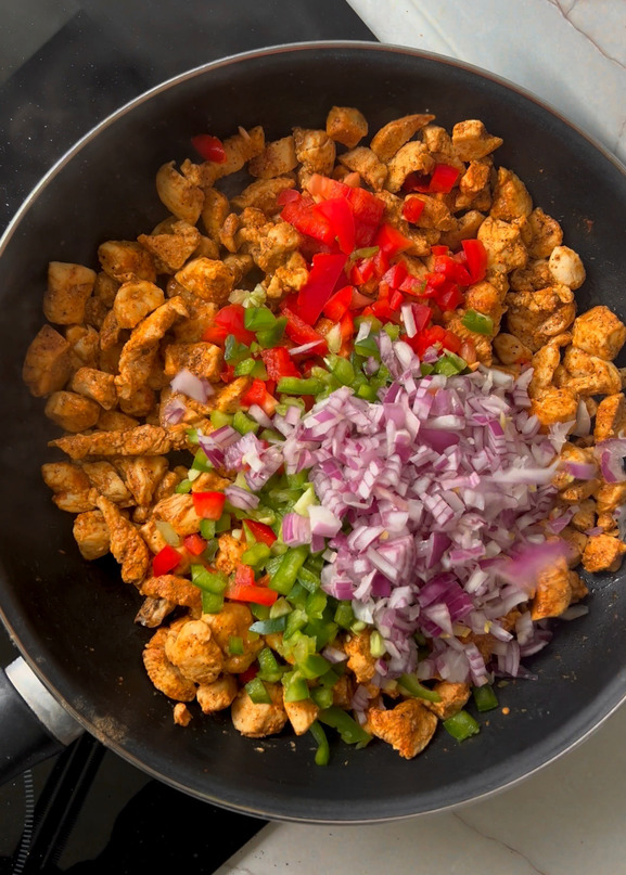 Cook the Chicken
Heat oil in a pan, add chicken and seasonings. Cook until tender and shred lightly. Add onions, bell peppers, and sauté until softened.