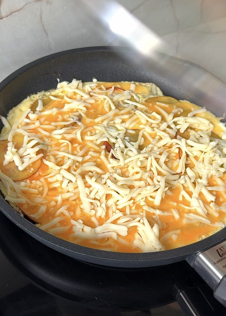 Add the Eggs and Cheese
Pour whisked eggs evenly over the potatoes, then sprinkle shredded mozzarella on top. Cover until the cheese starts to melt.