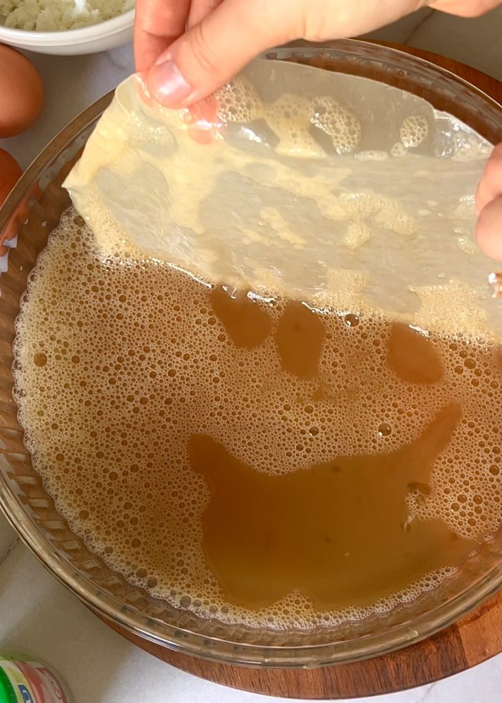 Whisk the Mixture: Combine egg, soy sauce, and water. Briefly dip two rice paper sheets to soften slightly.