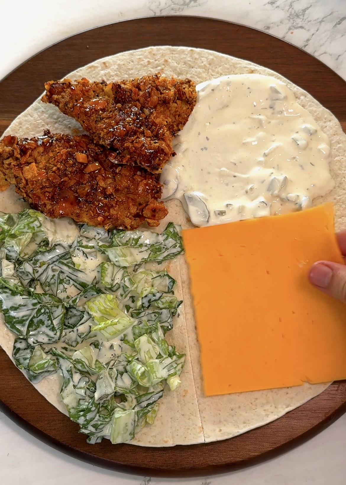 Chicken, lettuce and cheddar arranged on tortilla quarters