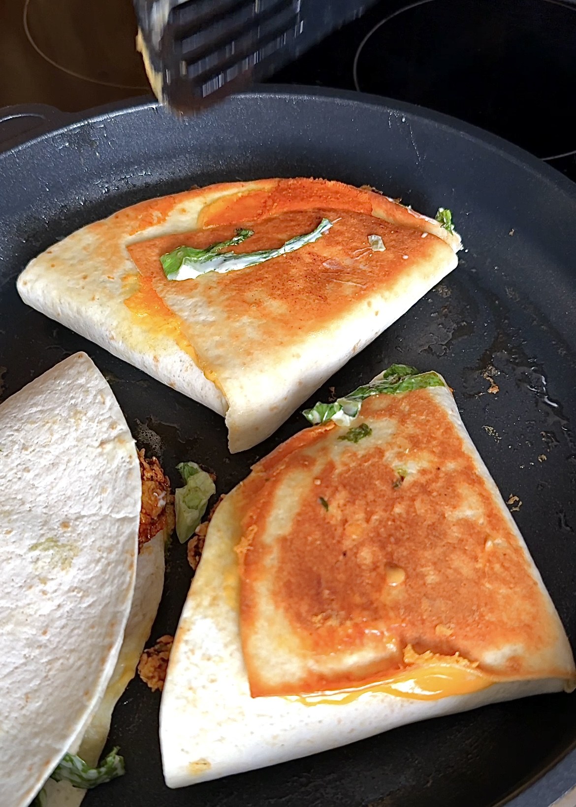 Folded chicken wraps toasted in a pan