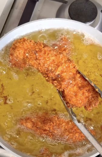 Breaded chicken tenders frying until golden