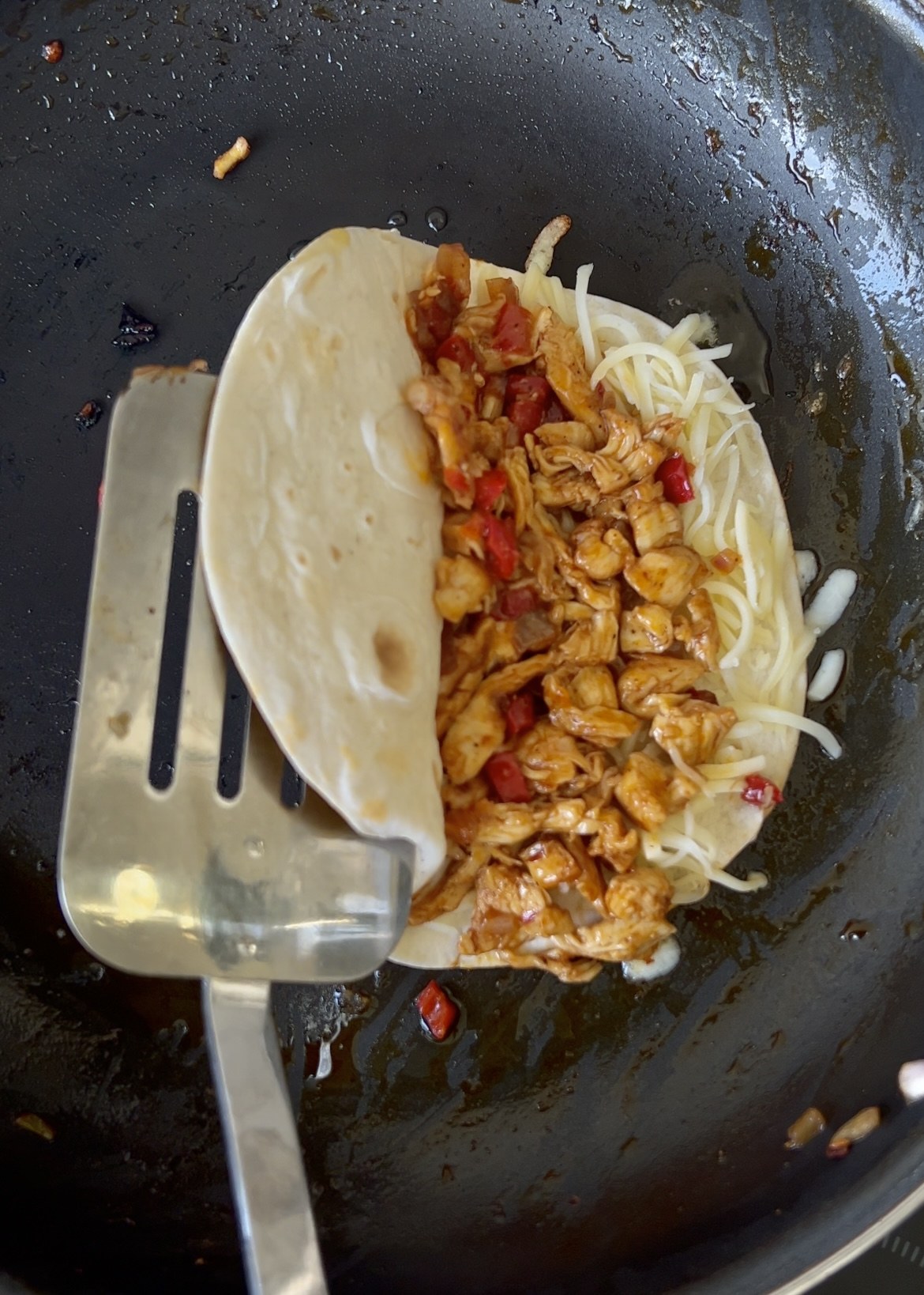 Folding a tortilla around honey BBQ chicken and cheese