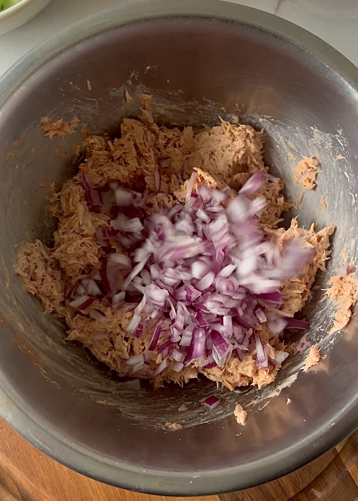 Mixing tuna with mayonnaise and chopped red onion