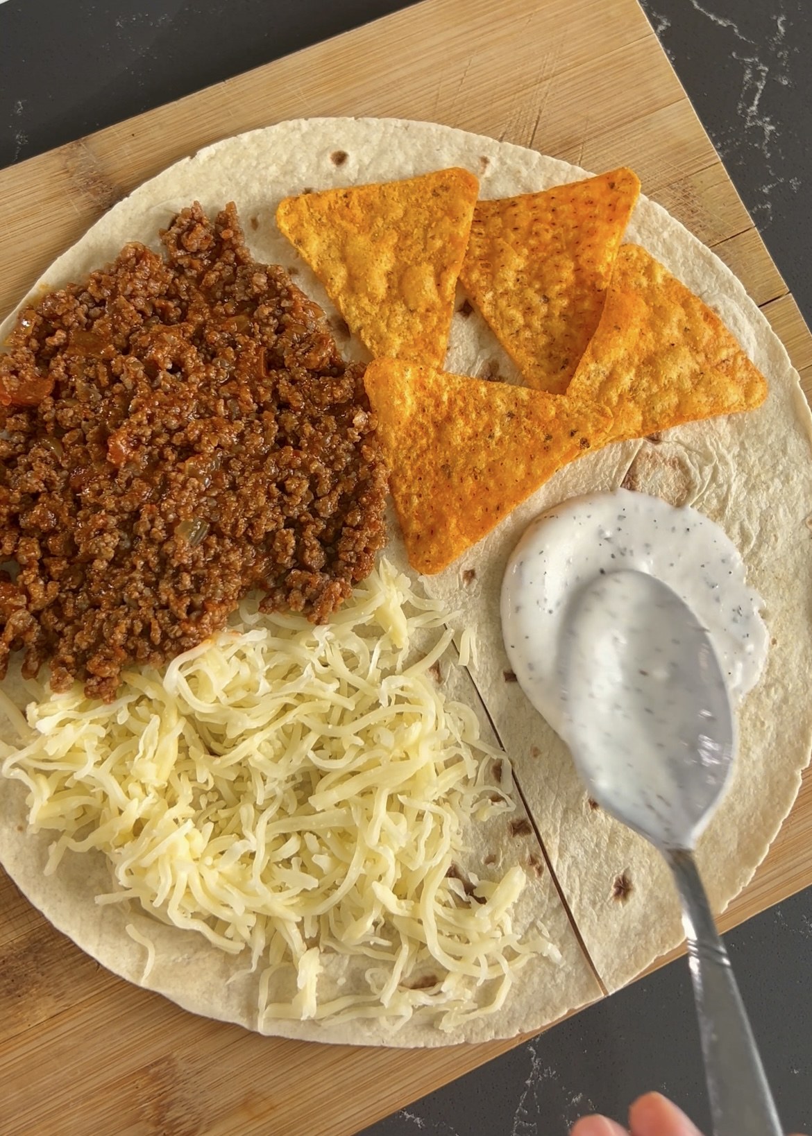Beef, tortilla chips and cheese arranged on tortilla quarters