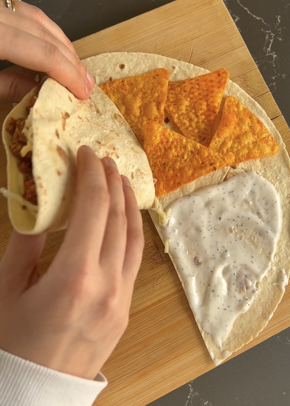 Folding the filled tortilla into a triangular wrap