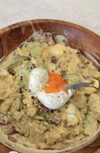 Creamy potato salad topped with a halved egg