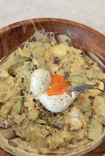 Creamy potato salad topped with a halved egg