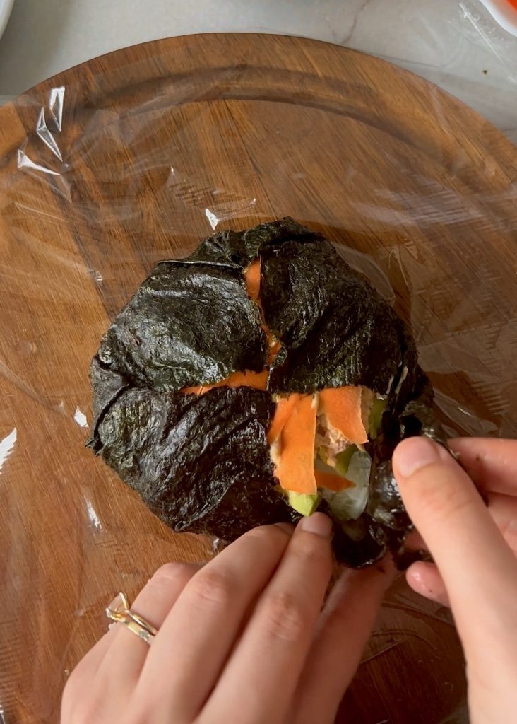 Sushi burger cut open with rice, tuna and vegetables
