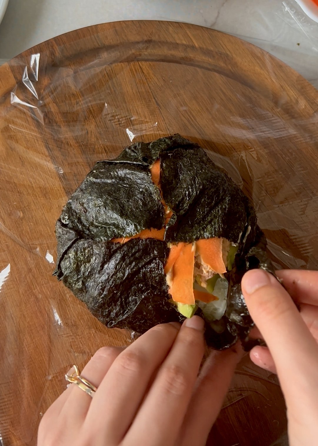 Sushi burger cut open with rice, tuna and vegetables